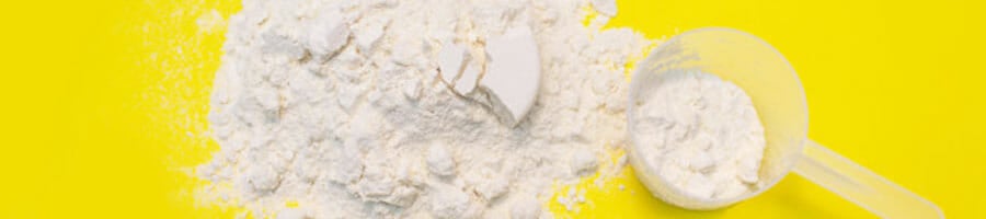 close up image of a protein scattered protein powder with a scooper