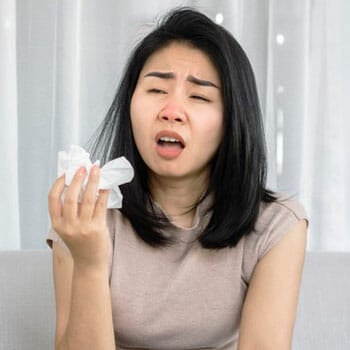 woman holding a tissue paper to sneeze