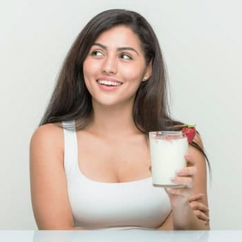 woman smiling while holding a glass of drink