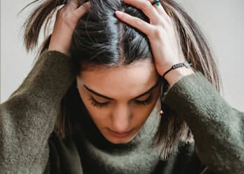 woman with both her hands on her head in panic