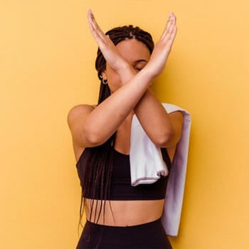 woman signing no with her arms while in gym clothes