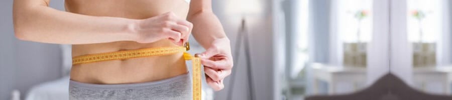 woman using a measuring tape on her waist