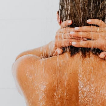 woman showing her back while taking a shower