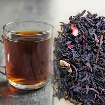 glass cup of black tea and black tea leaves