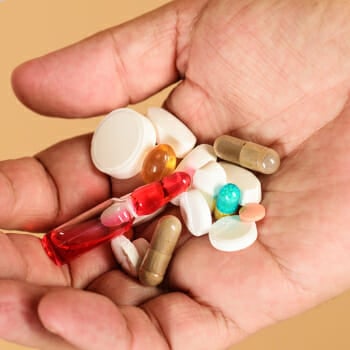 A person holding a different multivitamin supplements on his hand
