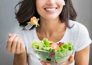 A woman eating vegetable salad