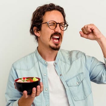 man in joy holding up a bowl of meal