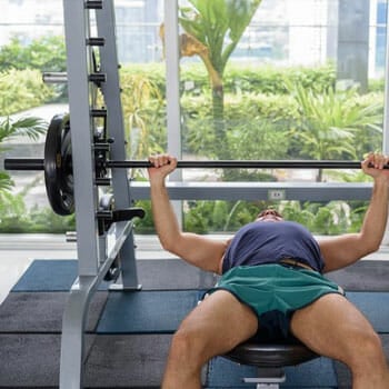 man lifting weights in a flat bench