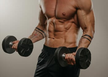 shirtless man doing dumbbell curls