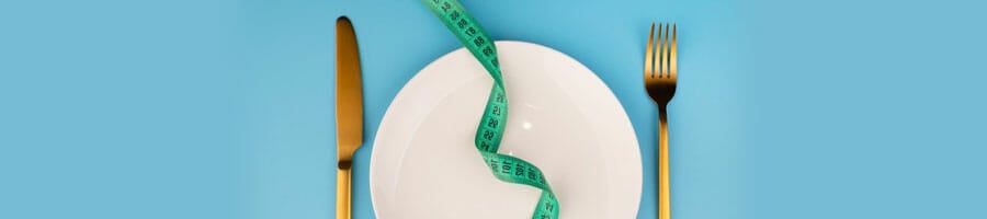 knife, plate, and a fork with a measuring tape on top