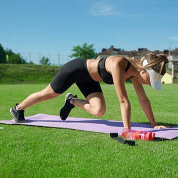 woman working out with a yoga mat outdoors