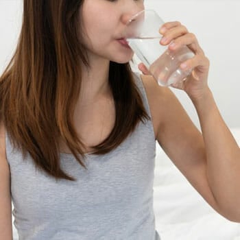 close up image of a woman drinking water from a glass