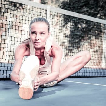 woman doing a seated leg stretch outdoors