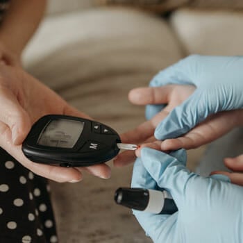 medical person checking a person's sugar blood level with a glucose meter