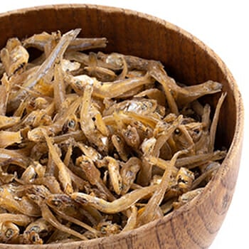 Dried anchovies fish in a wooden bowl