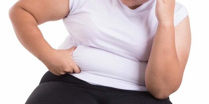 Woman in white shirt holding her belly fat