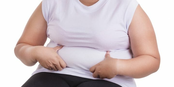 Woman holding her stomach rolls