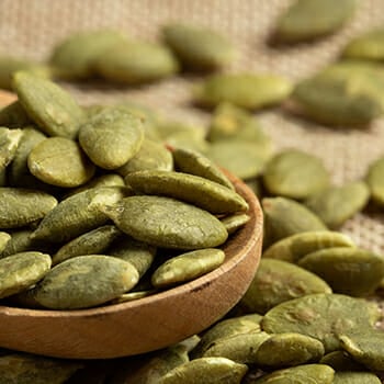 Pumpkin seeds on a wooden spoon