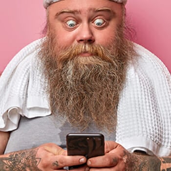 Bearded guy shocked looking at his phone when searching