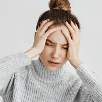A stressed woman holding her head