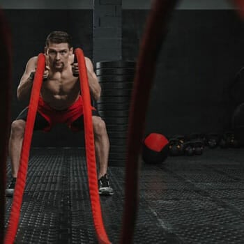 shirtless man doing HIIT rope workout