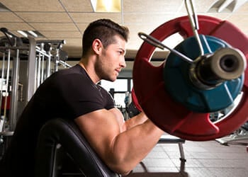 man using a barbell for his arms