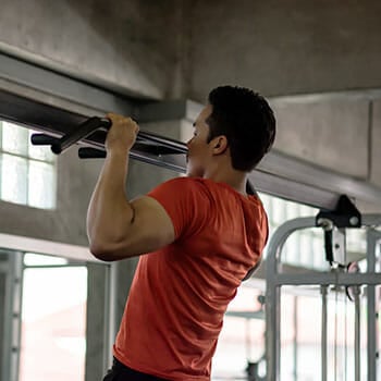 man using a pull up bar in a gym
