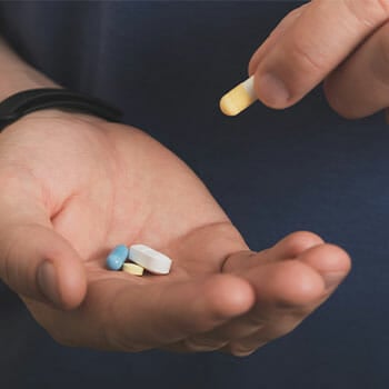 a man's hand filled with supplement pills