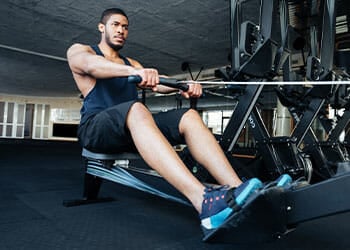 man using a rowing machine in a gym