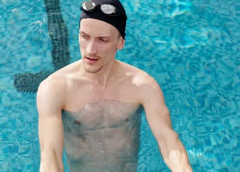 shirtless man standing in a pool