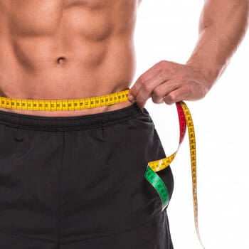 shirtless man with abs wrapping his belly with measuring tape