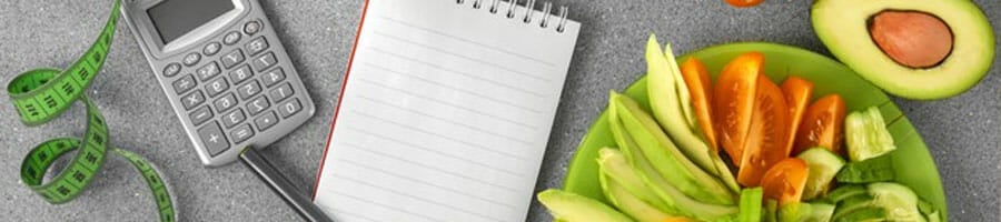 plate of vegetables with notebook, calculator and measuring tape on the table