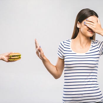 woman cover her eyes and saying no to burger