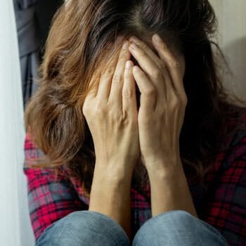 woman covering her face while crying