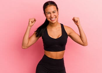 woman smiling while flexing both her arms