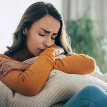 sad woman hugging her pillow