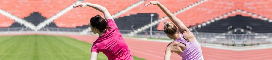 two ladies doing warm up exercises outdoors