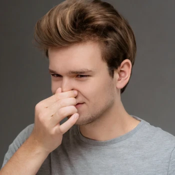 guy holding his nose because of a bad smell