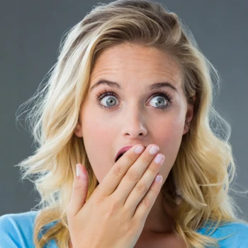 woman's hands covering her mouth in shock