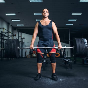 man lifting a heavy barbell in deadlift
