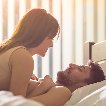 man and woman on top of each other in bed