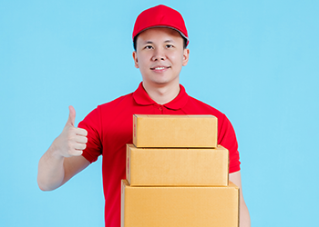 delivery guy holding up a box and his thumbs up