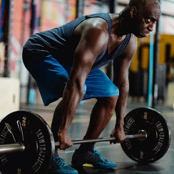 man lifting a barbell in a gym