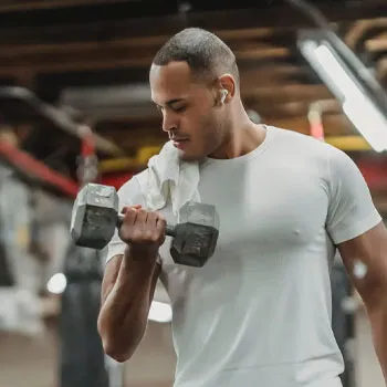man using dumbbells in a gym