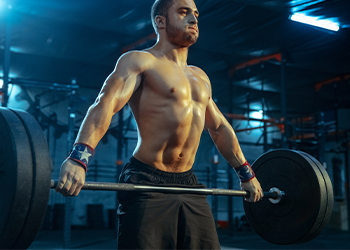 shirtless man lifting up a heavy barbell