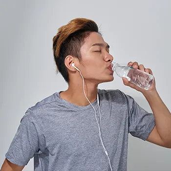 Man drinking from a plastic bottle
