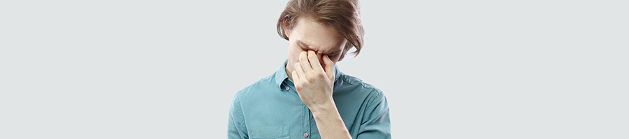 man holding his head in pain