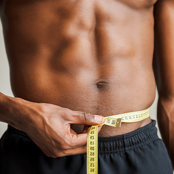 man using a measuring tape on his waist