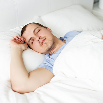 man laying down in bed sleeping