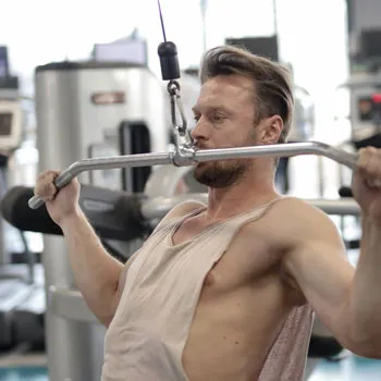 man doing a lat pulldown in a gym